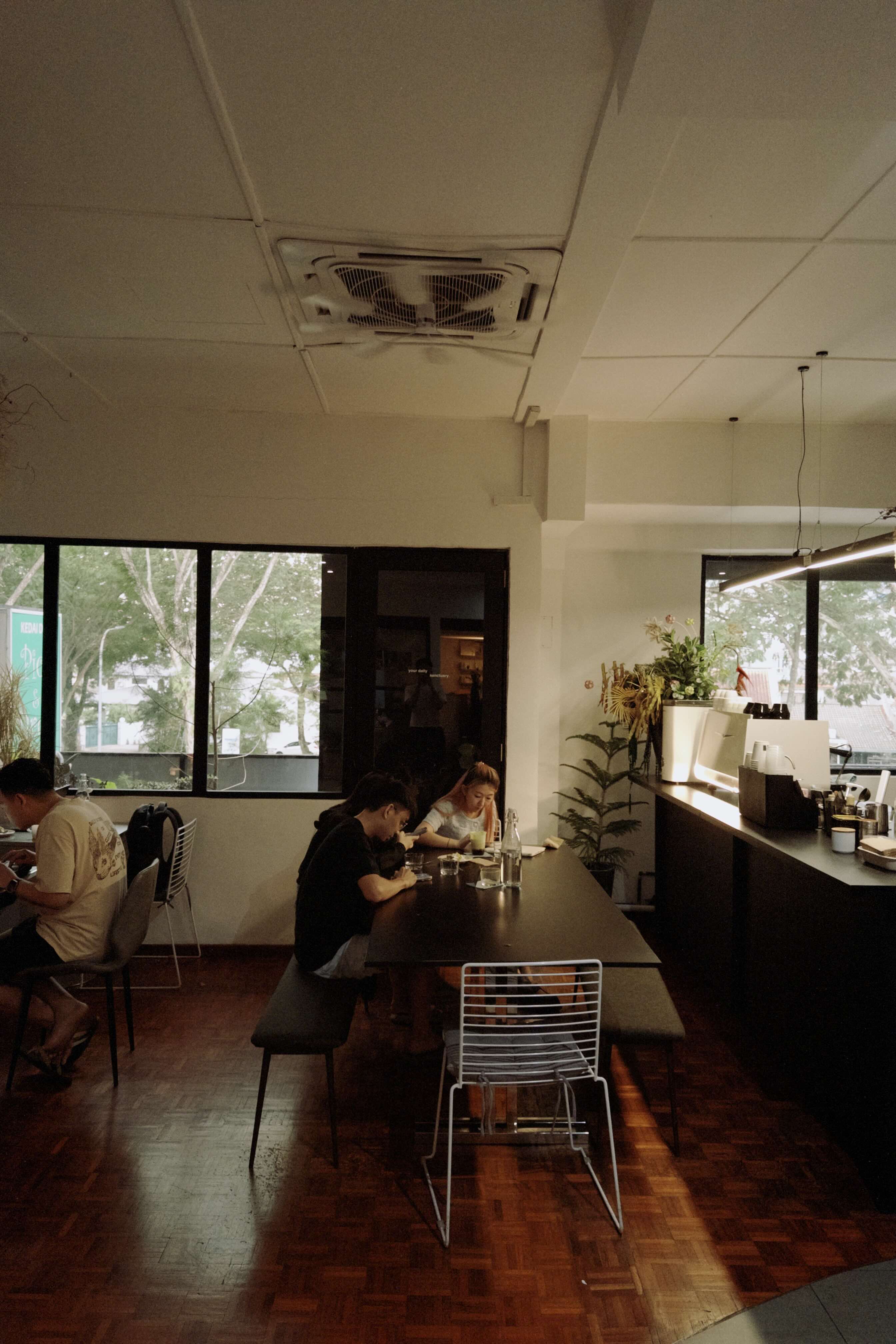 People sitting at a long table in a modern office setting with large windows.